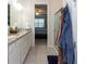 The bathroom boasts double sinks and granite countertops and a shower; the bedroom is in the background at 10313 Wine Press Ave, Riverview, FL 33578