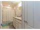 Bright bathroom featuring a granite vanity countertop and beach themed shower curtain at 10313 Wine Press Ave, Riverview, FL 33578