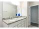 This bathroom features a granite countertop, a wide mirror and white cabinets at 10313 Wine Press Ave, Riverview, FL 33578