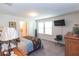 A bedroom with a TV, a brown floral comforter and an ensuite bathroom for the homeowners at 10313 Wine Press Ave, Riverview, FL 33578