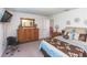 A bedroom with a TV, and wooden dresser and brown floral comforter on the bed at 10313 Wine Press Ave, Riverview, FL 33578