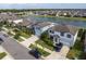 This exterior shot shows a neighborhood street with several houses, landscaping, and a beautiful lake at 10313 Wine Press Ave, Riverview, FL 33578