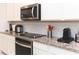 Modern kitchen features stainless steel appliances, white cabinetry, granite countertops, and subway tile backsplash at 10313 Wine Press Ave, Riverview, FL 33578