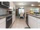 Modern kitchen boasts stainless steel appliances, granite countertops, and an open view of the dining area at 10313 Wine Press Ave, Riverview, FL 33578