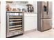 Gourmet kitchen featuring a wine refrigerator, granite countertops, and ample cabinet space for storage at 10313 Wine Press Ave, Riverview, FL 33578