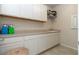 Bright laundry room features white cabinetry, countertop, and sink for added convenience at 10313 Wine Press Ave, Riverview, FL 33578