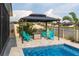 Backyard oasis featuring a gazebo with Adirondack chairs and beautiful pool views at 10313 Wine Press Ave, Riverview, FL 33578