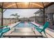 Relaxing pool view featuring a gazebo, fire table, and comfortable blue Adirondack chairs at 10313 Wine Press Ave, Riverview, FL 33578