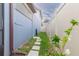 Narrow side yard with stone pavers, a blue house exterior, and a white fence on a sunny day at 10313 Wine Press Ave, Riverview, FL 33578