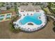 Aerial view showcasing the community's clover-shaped pool, sun loungers, cabana, and tennis courts at 10313 Wine Press Ave, Riverview, FL 33578