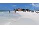 Sandy beach with clear shallow water, people, and lush trees at 105 Woodlake Wynde, Oldsmar, FL 34677
