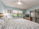 Relaxing bedroom with a view to the outside featuring wood floors and light blue walls at 105 Woodlake Wynde, Oldsmar, FL 34677