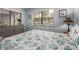 Neutral guest bedroom featuring a window with blinds, hardwood floors, and beach-themed decor at 105 Woodlake Wynde, Oldsmar, FL 34677