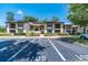 A condominium with two stories, a parking lot, sidewalks and green space at 105 Woodlake Wynde, Oldsmar, FL 34677