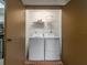 Convenient laundry room featuring a washer, dryer, and storage shelf for supplies at 105 Woodlake Wynde, Oldsmar, FL 34677