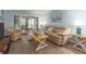 Comfortable living room with neutral-toned furniture, wood-look floors, and access to an outdoor patio at 105 Woodlake Wynde, Oldsmar, FL 34677
