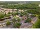 Expansive aerial view of a community with ponds, mature trees, and ample parking at 1118 Kennewick Ct, Wesley Chapel, FL 33543
