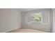 Neutral bedroom with light wood floors, large window, and a double door closet at 1118 Kennewick Ct, Wesley Chapel, FL 33543