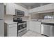 This is a bright kitchen featuring stainless steel appliances, tile floors, and white cabinets at 1118 Kennewick Ct, Wesley Chapel, FL 33543
