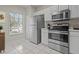 Bright kitchen with stainless steel appliances, white cabinetry, and tiled flooring for a clean and modern look at 1118 Kennewick Ct, Wesley Chapel, FL 33543