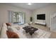 Comfortable living room featuring a large sofa, sliding glass doors, and a sleek entertainment center with decor at 1118 Kennewick Ct, Wesley Chapel, FL 33543