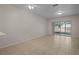 Spacious living room with neutral tile floors, large windows and sliding glass doors for great natural light at 1118 Kennewick Ct, Wesley Chapel, FL 33543