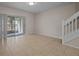 A spacious living room features tile flooring, stairs to the second floor, and a sliding glass door at 1118 Kennewick Ct, Wesley Chapel, FL 33543