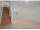Open living area features tile flooring, stairs to the second floor, and natural light at 1118 Kennewick Ct, Wesley Chapel, FL 33543