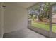 Enclosed patio offers a private outdoor space with a view of the green lawn and mature trees at 1118 Kennewick Ct, Wesley Chapel, FL 33543