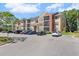 Three-story condo building with tan and rust colored facade and ample parking at 11901 4Th N St # 8207, St Petersburg, FL 33716