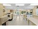 Well-lit laundry room featuring multiple washers, dryers, and folding tables for residents' convenience at 11901 4Th N St # 8207, St Petersburg, FL 33716