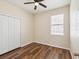 Well-lit bedroom with wood-look floors, a closet, and a window at 12212 Mcmullen Loop, Riverview, FL 33569