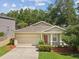 Charming one-story home with a manicured lawn and two-car garage, nestled among mature trees in a serene neighborhood at 12212 Mcmullen Loop, Riverview, FL 33569