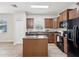 Functional kitchen featuring an island, granite counters, wood cabinets, and stainless steel appliances at 12212 Mcmullen Loop, Riverview, FL 33569
