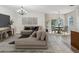 Bright living room featuring a large sectional sofa, modern lighting, and tile floors leading to dining area at 12212 Mcmullen Loop, Riverview, FL 33569