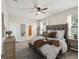 Relaxing main bedroom with a ceiling fan, a plush bed and an ensuite bathroom at 12212 Mcmullen Loop, Riverview, FL 33569