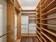 A huge walk-in closet featuring custom wood shelving and wood-look flooring at 12212 Mcmullen Loop, Riverview, FL 33569