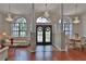Elegant foyer featuring hardwood floors, a decorative glass door, and crystal chandeliers at 12501 Palomino Ct, Tampa, FL 33626