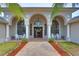 Grand front entrance with arched columns, glass double doors, and meticulously landscaped walkway at 12501 Palomino Ct, Tampa, FL 33626