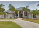 Elegant home featuring arched entryway, detailed trim, and a well-manicured lawn and circular driveway at 12501 Palomino Ct, Tampa, FL 33626