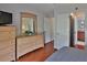 Main bedroom featuring hardwood floors, a dresser with a decorative mirror, and multiple doorways at 12501 Palomino Ct, Tampa, FL 33626