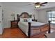 Luxurious main bedroom featuring hardwood floors, an elegant bed frame, and a ceiling fan at 12501 Palomino Ct, Tampa, FL 33626