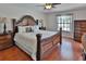 Luxurious main bedroom featuring hardwood floors, an elegant bed frame, and a ceiling fan at 12501 Palomino Ct, Tampa, FL 33626