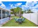 Fenced backyard featuring a well-maintained lawn, patio furniture, and lush landscaping perfect for outdoor living at 13404 Fladgate Mark Dr, Riverview, FL 33579