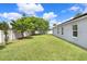 Expansive backyard with a lush green lawn, mature trees, and a white fence, offering privacy and space at 13404 Fladgate Mark Dr, Riverview, FL 33579