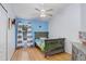Comfortable bedroom featuring light-colored walls, light hardwood floor, ceiling fan, and a gray bed frame at 13404 Fladgate Mark Dr, Riverview, FL 33579