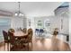 Bright dining room with hardwood floors, a classic chandelier, and a view of the well-lit front entrance at 13404 Fladgate Mark Dr, Riverview, FL 33579