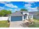 Charming single-story home featuring a well-manicured lawn and a blue two-car garage in a peaceful neighborhood at 13404 Fladgate Mark Dr, Riverview, FL 33579