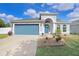 Attractive home showcasing a two-car garage, arched entryway and a meticulously landscaped front yard at 13404 Fladgate Mark Dr, Riverview, FL 33579