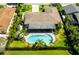 Aerial view of home, kidney-shaped pool, patio, tropical landscaping, and well manicured yard at 13916 Wellesford Way, Tampa, FL 33624